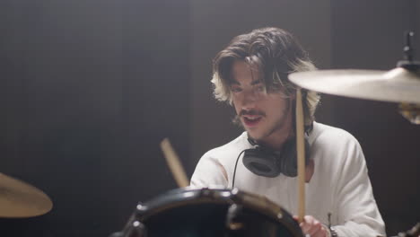 drummer in trendy shirt playing drums at music studio