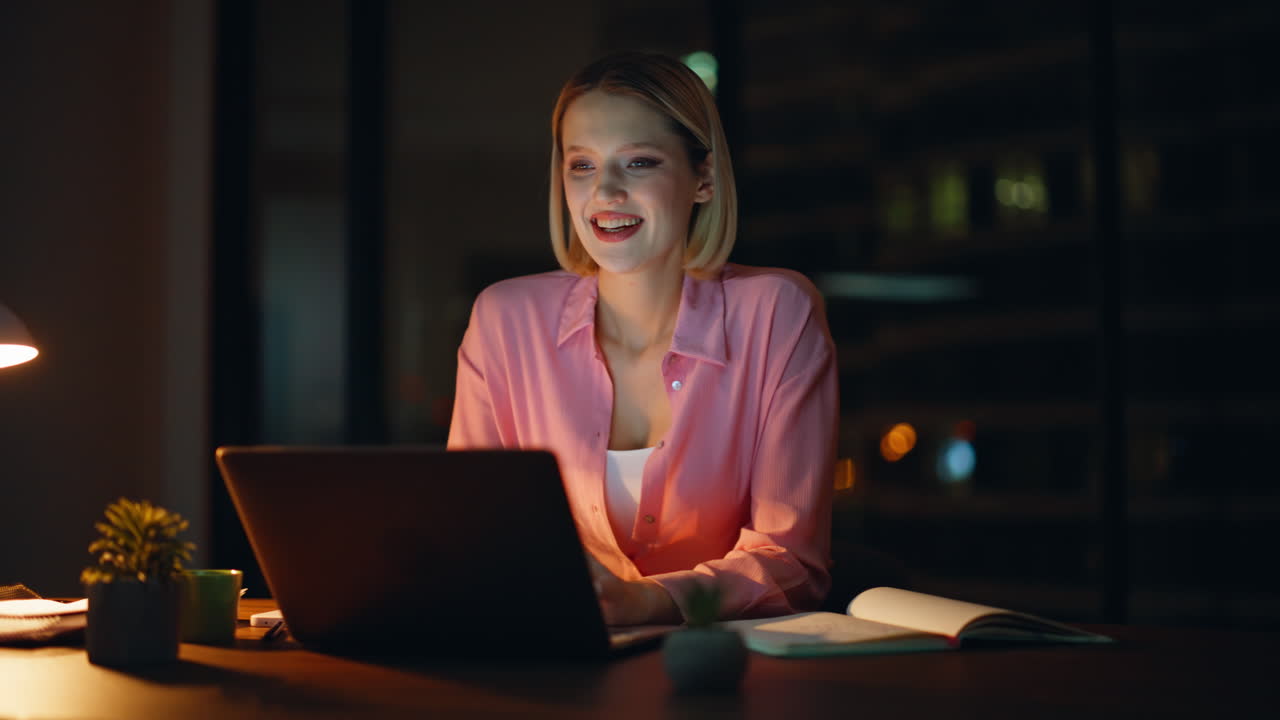 mujer trabajando en una computadora portátil por la noche