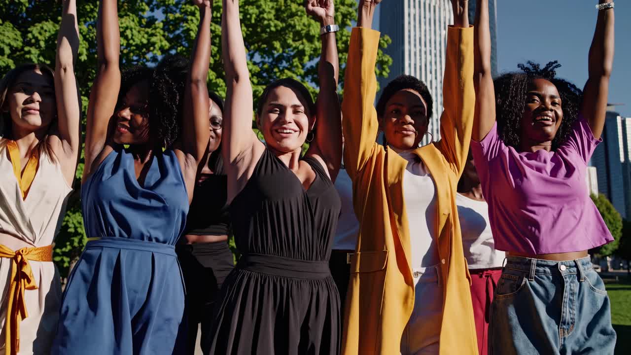 A diverse group of women standing confidently in a park, captured from a low-angle