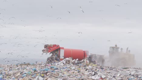 vehicles clearing rubbish piled on a landfill full of trash