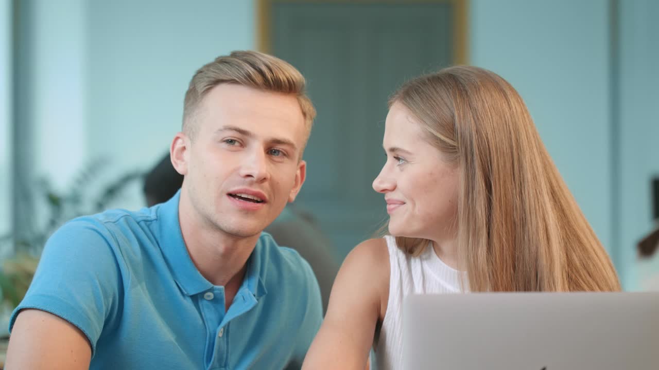 Handsome man telling story sitting at coworking. Pretty woman listening story