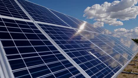 low-angle video shot of solar panels under a bright blue sky with clouds, emphasizing renewable