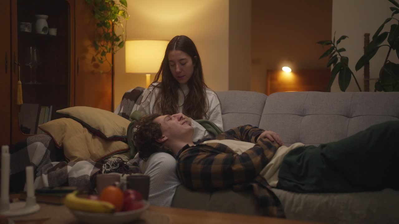 부부는 집에서 소파에서 휴식을 취하고 있습니다.