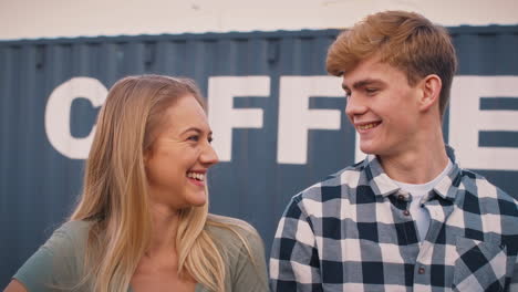 portrait of male and female interns at freight haulage business standing by shipping container