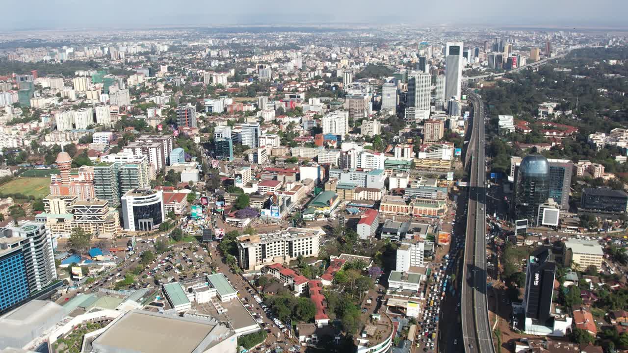 A beautiful aerial drone footage of the city of Nairobi, Kenya, showcasing the bustling urban office spaces, modern residential areas, the Nairobi Expressway, and Waiyaki Way. Captured during the day