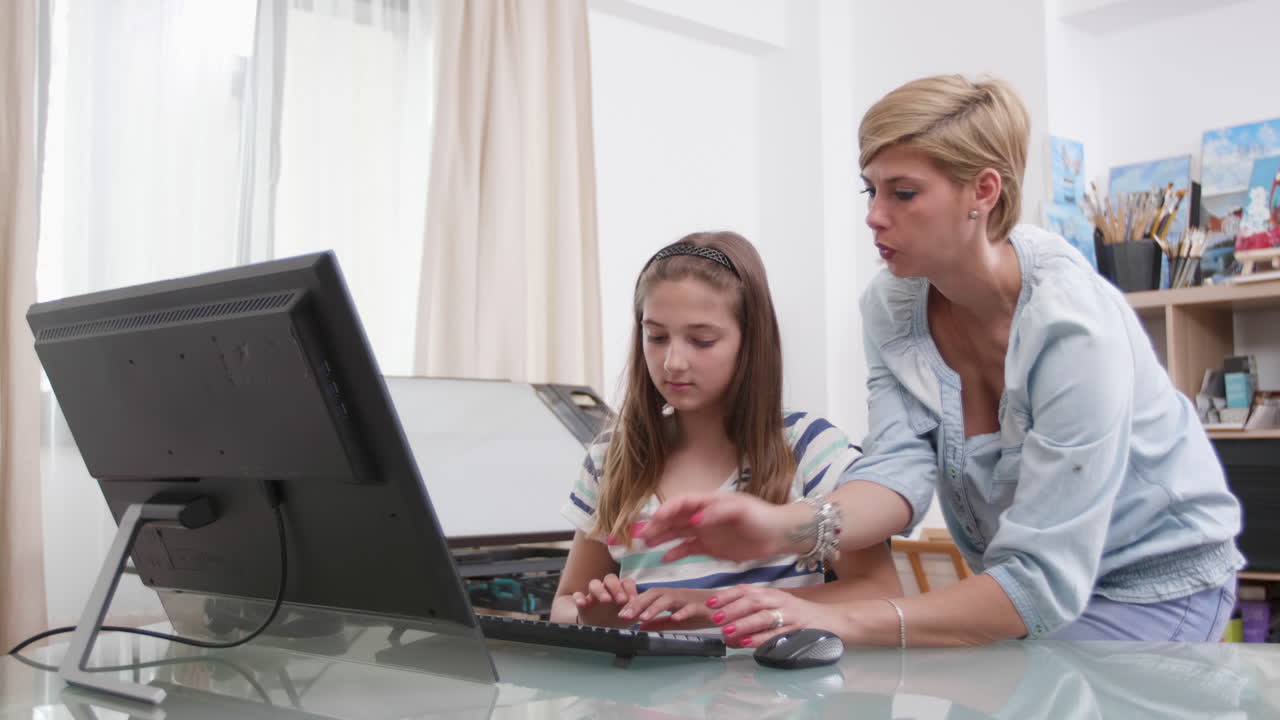 Mother and daughter using computer at home