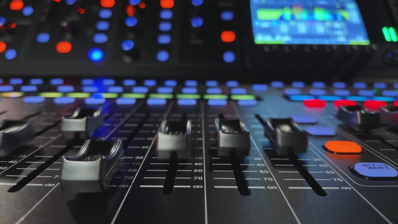 faders en movimiento en la consola de mezclas digital, vista de primer plano, luces borrosas en segundo plano
