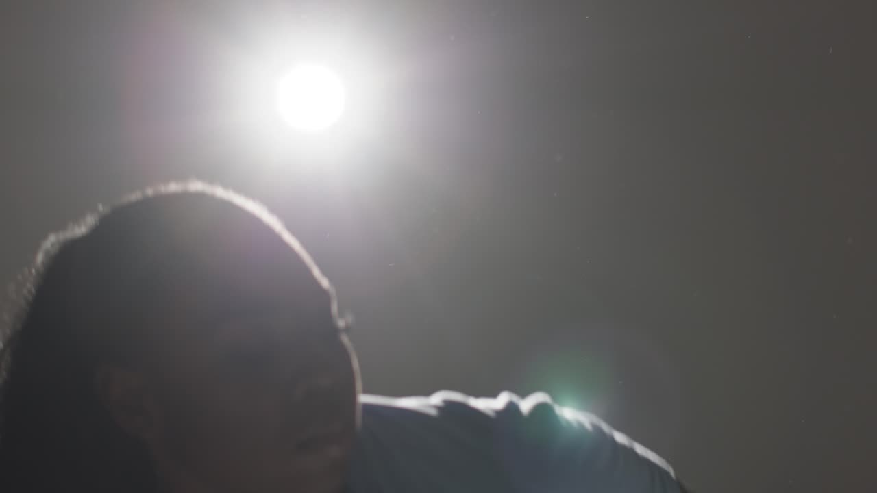Backlit Head And Shoulders Studio Portrait Shot Of Young Woman Dancing In Spotlight 7
