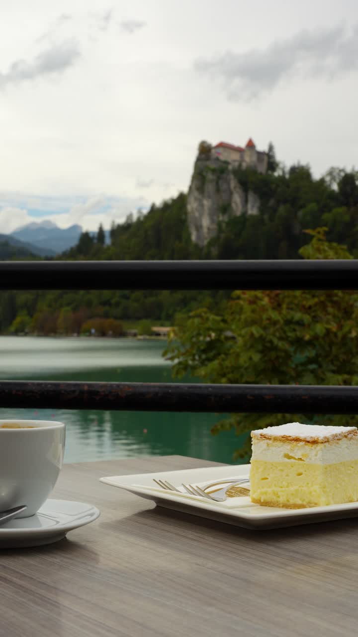 Bled cream cake Kremsnita on plate at Kavarna Park Cafe in Bled, Slovenia by lake water, vertical pan