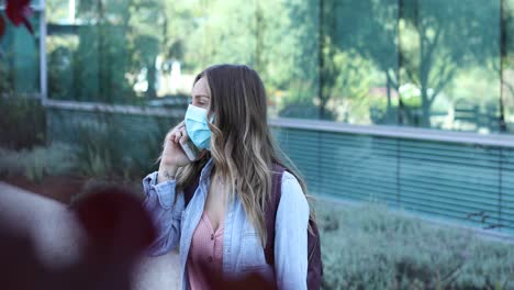 A-cleared-female-nurse-or-woman-with-mask-walks-talking-on-teléfono-during-the-Covid19-coronavirus-pandemic-epidemic