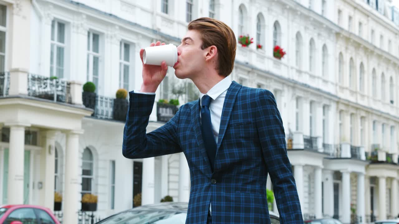 joven elegante llevando café de pie en la calle de la ciudad