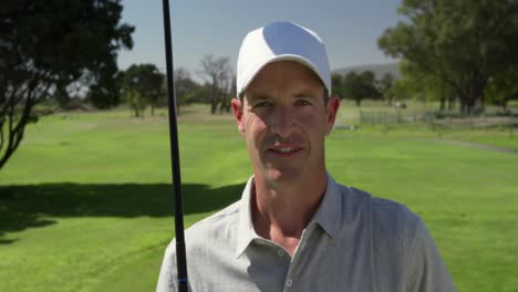 Golfista-Caucásico-Sonriendo-A-La-Cámara-En-Un-Campo-De-Golf