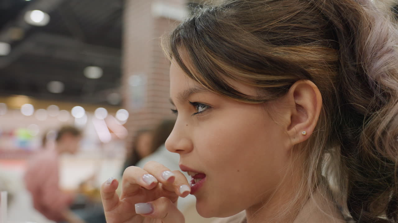 adolescente disfrutando de un capricho en un centro comercial concurrido, adolescente caucásico probando un dulce en un bullicioso centro comercial, escena informal de una persona joven degustando un postre en la zona de restauración de un centro comercial