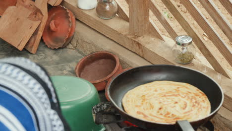 Traditionelle-Afrikanische-Kochszene-Mit-Einem-Chapati,-Einer-Art-Fladenbrot,-Das-In-Einer-Bratpfanne-über-Offener-Flamme-Gekocht-Wird