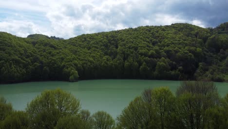 Drone-Shot-Reveal-Turquoise-Water-At-Mountain