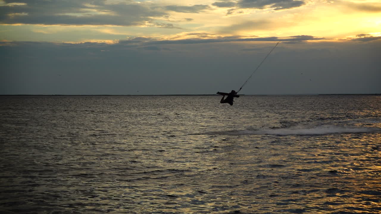 Kiteboarding. Gerak lambat. Matahari terbenam di atas laut. Olahraga