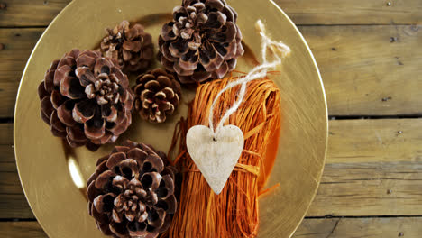 pine cones and heart shape decoration in a plate 4k