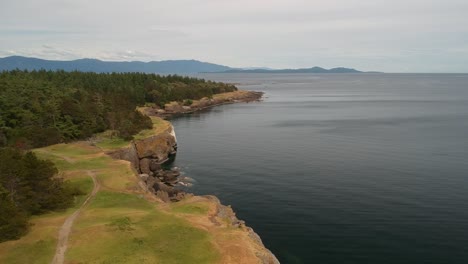 drone shot of bluffs with ocean views and green grass