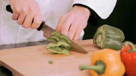 woman cutting a green pepper in slow motion