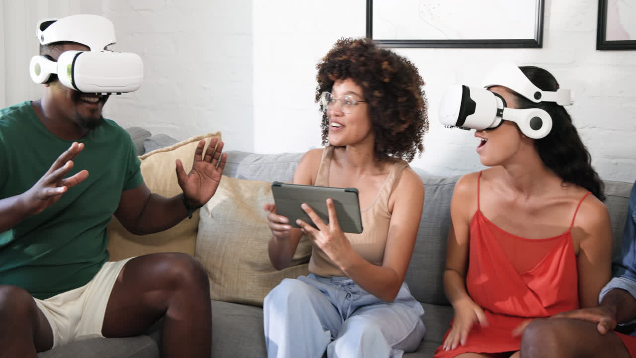 Diverse friends enjoying virtual reality games on couch, laughing and having fun together, at home