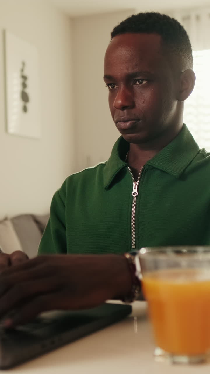 Young Black Man Typing on Laptop at Home