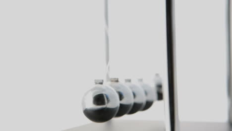 newtons cradle in motion on white background