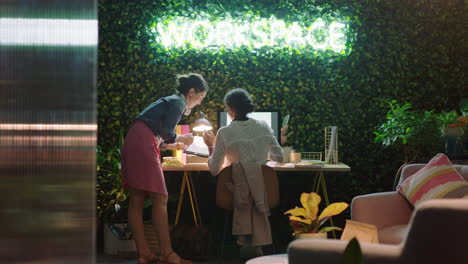 business people working late using tablet computer team leader woman sharing ideas showing colleague pointing at screen discussing project information in modern office at night