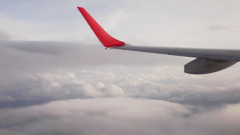 low cost airplane wing flying through sea clouds