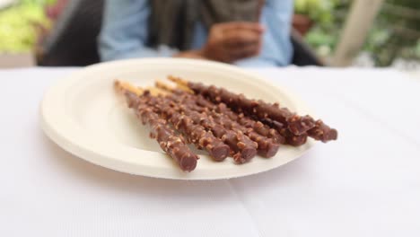 dunkle schokoladenstange mit mandelnuss auf dem tisch