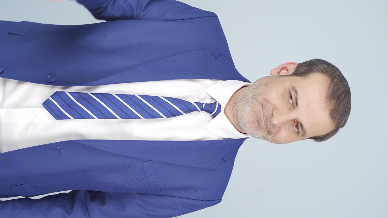 вертикальное видео неудачного бизнесмена. он смотрит на камеру негативно.