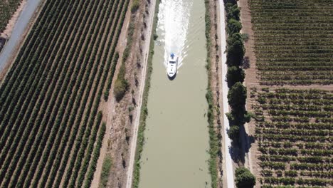 Leisure-Boat-sails-between-the-vineyards,-Somail-Canal-Du-Midi-South-Of-France