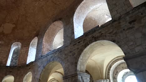 panning shot of stone arches inside of a building inside the tower of london, uk