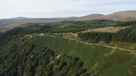 Vista-Aérea-De-Una-Larga-Y-Sinuosa-Carretera-De-Montaña-Vacía-En-Las-Montañas-De-Wicklow-En-Un-Día-Soleado