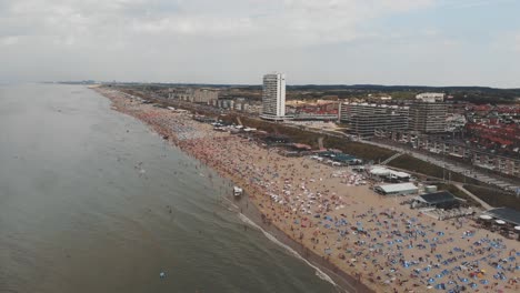 Aerial-footage-of-a-crowded-beach-along-near-Zandoort,-Netherlands-of-the-North-Sea