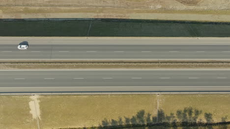 Draufsicht-Auf-Ein-Einzelnes-Auto-Auf-Einer-Breiten,-Leeren-Autobahn