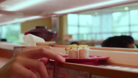 conveyor belt sushi restaurant scene with patrons and passing dishes