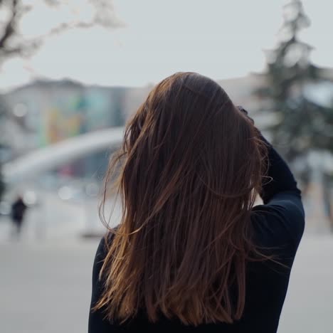 back view of a woman walking in the autumn park with long dark hair turning back to the camera. selective focus used in video