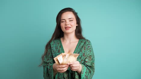 rich woman showing euro banknotes in blue studio