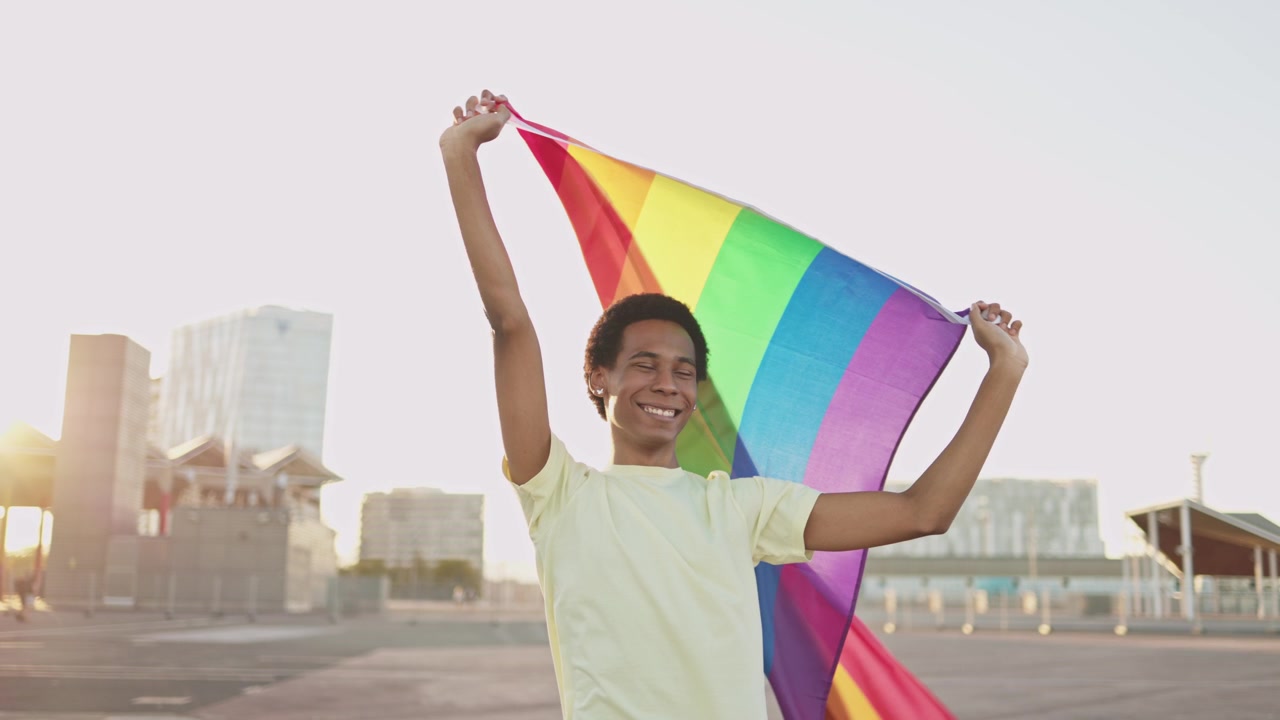 Happy Young Person Holding Rainbow Pride Flag Outdoors