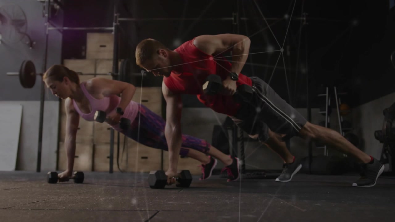 Uomo e donna che partono da una posizione di plank alto afferrando manubri, alternando remate lente per il fitness.