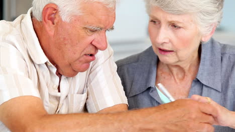 una pareja de ancianos pagando sus cuentas.