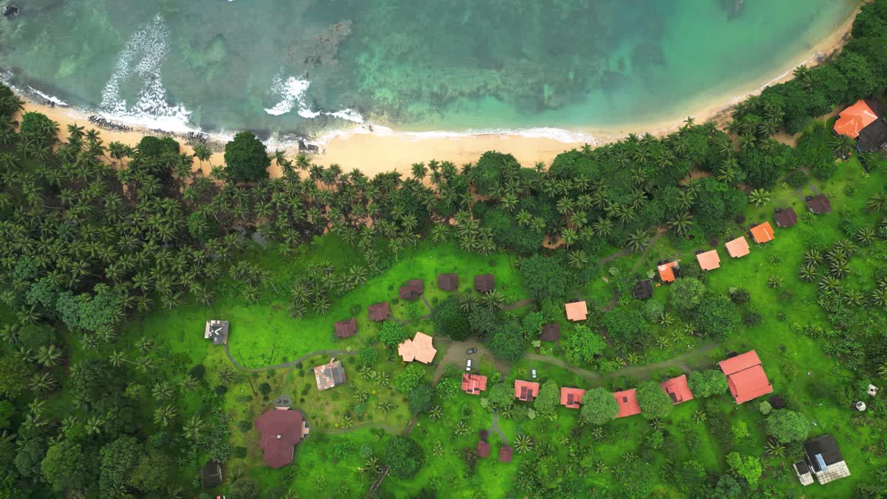 アフリカのサントメにあるイニャーメビーチの小屋の上空を真上から撮影したドローン映像。晴れた日。