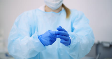 doctor pulls off protective gloves