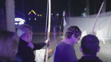 people aims a bow at a target. vinnitsa, ukraine, march 2017: people is trying aims a bow at a target
