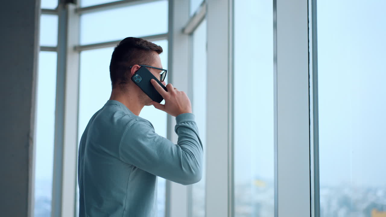 Man on Phone at Office Window