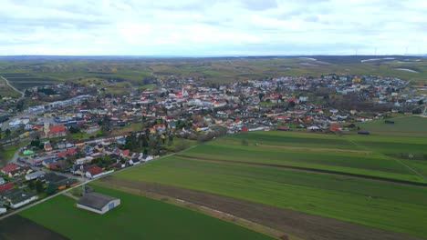 Vista-Panorámica-Aérea-De-La-Ciudad-Rural-Con-Vastos-Campos-De-Hoja-Perenne