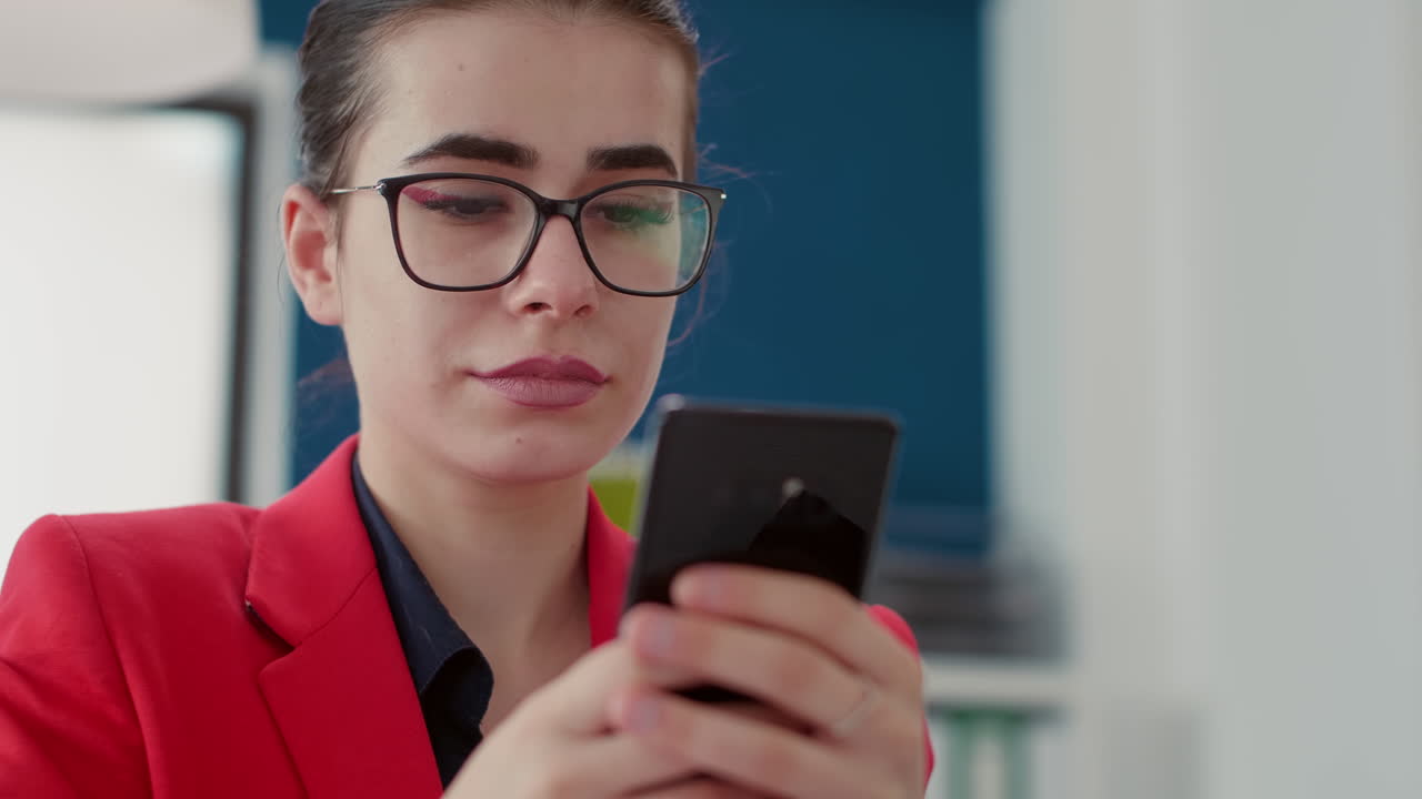 Office worker browsing internet on smartphone at desk