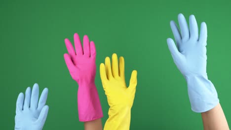 manos con guantes de goma protectores que se levantan y comienzan a saludar, haciendo gestos de mano de despedida en el fondo de la pantalla verde de chroma key. video 4k