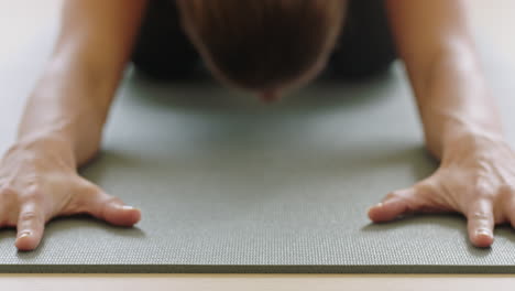 close up yoga woman practicing childs pose enjoying fitness lifestyle exercising in studio stretching body training on exercise mat