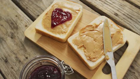 close up view of peanut butter and jelly sandwich on wooden tray on wooden surface